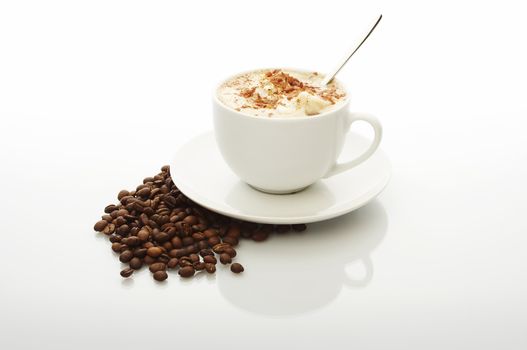 White cup of cappuccino with coffee beans