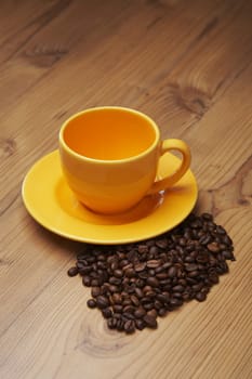 Empty yellow coffee cup on a wooden kitchen table