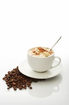 White cup of cappuccino with coffee beans