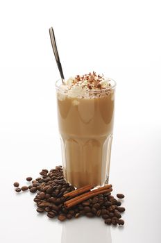 White cup of latte with coffee beans and cinnamon