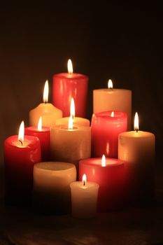 A group of burning candles in red and white