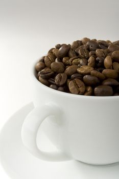 Coffee cup filled with roasted coffee beans