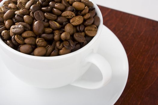 Coffee cup full of coffee beans on the table