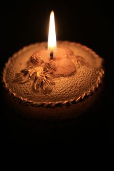 A detail of a burning decorated christmas candle