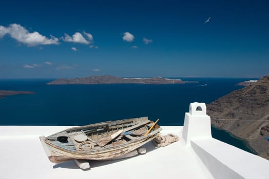 Old damaged  rowing boat placed on house roof