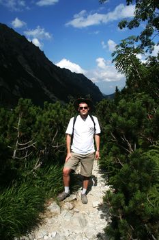 Man walking on the mountains over blue sky