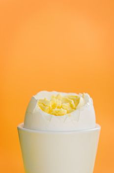 Boiled egg standing on the orange background