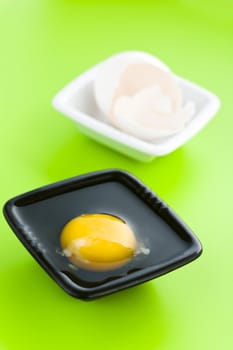 Broken egg separated to two vases on greeen table