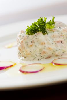 Creamy salmon mousse with vegetables on the plate