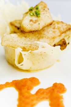 White fish on the cheese basket with pepper dressing