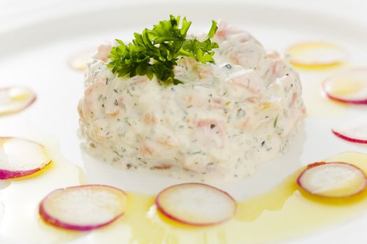 Creamy salmon mousse with vegetables on the plate