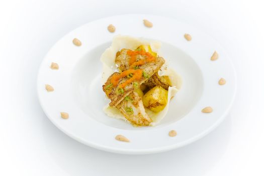 White fish and pinapple with peanut and pepper dressing on the plate