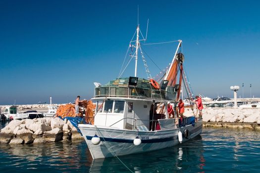 Few fishermans prepare shrimp boat to sail out