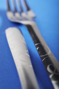 Two forks facing different dirrections on blue background