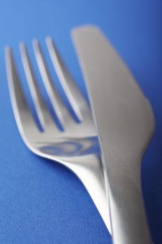 close up of a fork and spoon on blue background
