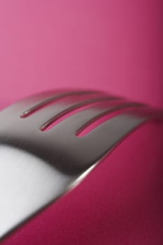 Close up of fork on the pink table