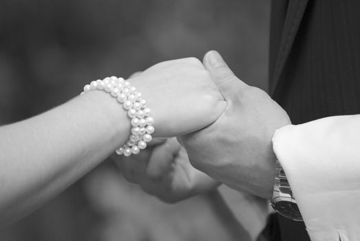 Close up of wedding couple holding hands. Photo in black and white