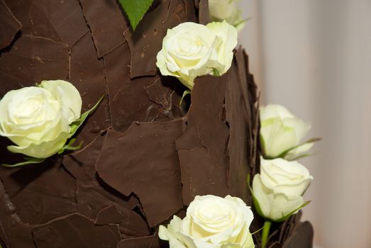 Brown choclate wedding cake decorated with light yellow roses