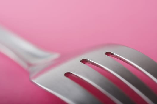 Close up of fork on the pink table