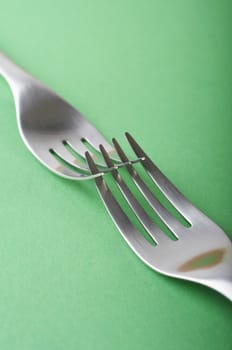 Two forks crossed on the green table