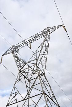 Electricity pylon with cables running accross the frame and clouds in the background