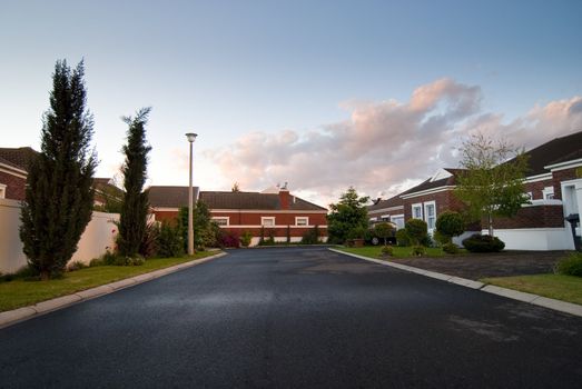 Modern facebrick house with small garden and dramatic clouds overhead