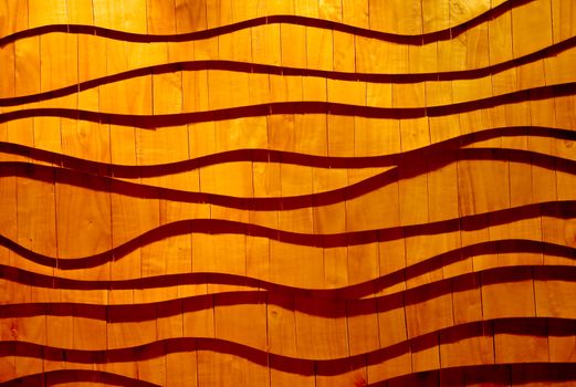 Wooden wall panels as flowing waves, casting shadows