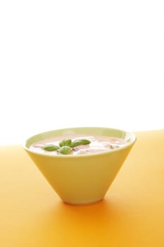 Fruits with yoghurt  over a orange background (lots of copy space)