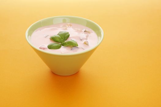 Fruits yoghurt in a bowl over a orange background