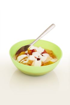 Fruit cocktail with vanilla sauce over a white background