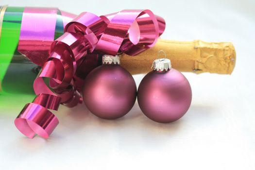 A bottle of champagne and purple christmas decorations