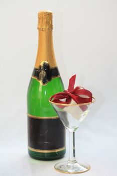 A bottle of champagne and a ring box in a glass, champagne proposal