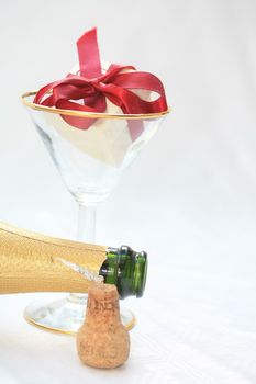 Open bottle of champagne and a ringbox in a champagne glass, a champagne proposal