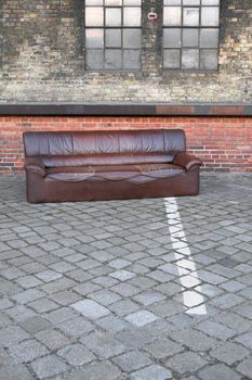 Need a sofa? Bulky waste dumped in an abandoned industrial backyard.