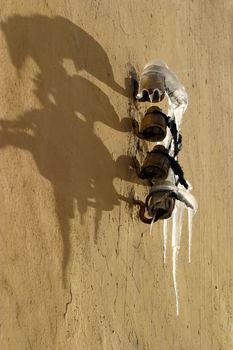 Iicicles on the yellow wall and shadows