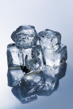 Ice cubes on the reflective light blue table