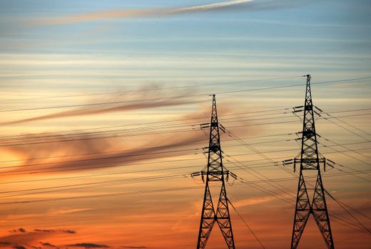 High voltage tower on a background of the red sky
