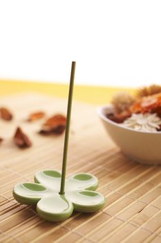 Incense sticks on the orange table with dried flowers