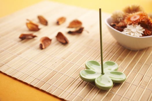 Aroma therapy setup (dried flowers, incense stick, bamboo mat)