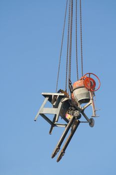 Equipment of a construction site is hanging on a crane high above the earth in order to prevent theft of metall pieces over the weekend.