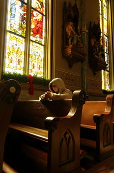 A woman praying at a church at Christmas.