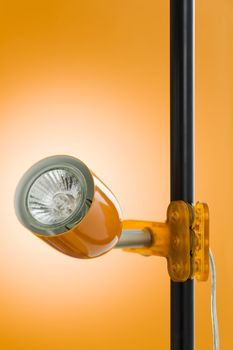 Halogen spot clamp lamp over a orange background
