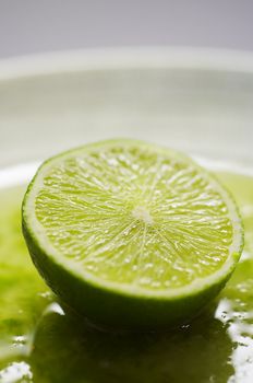 Green lime on the plate with juice