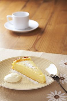 Home made icing sugar topped lime tart with cream on the table