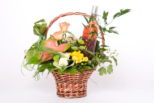 Basket of flowers with bottle of cherry vodka