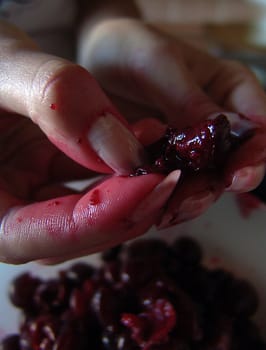 The girl separates косточки from a cherry