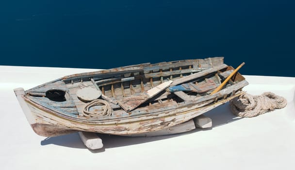 Old damaged rowing boat withpaddles and rope