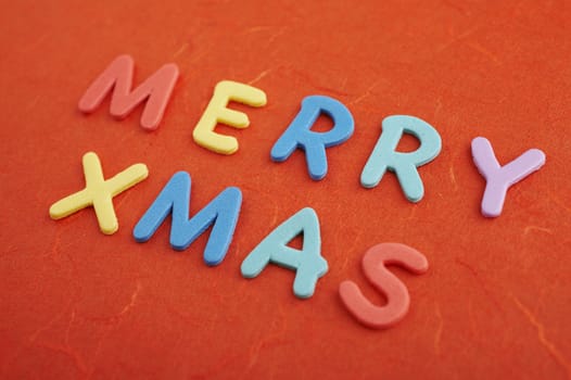 Merry christmas text (colorful soft rubber letters) on red silk paper