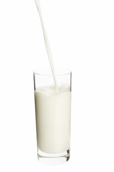Pouring milk in the glass on the white background