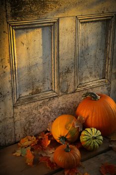 Pumpkins, broom and gourds at the door ready for halloween/ Sepia tone